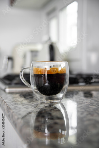 Espresso coffee in double walled glass cup on kitchen counter
