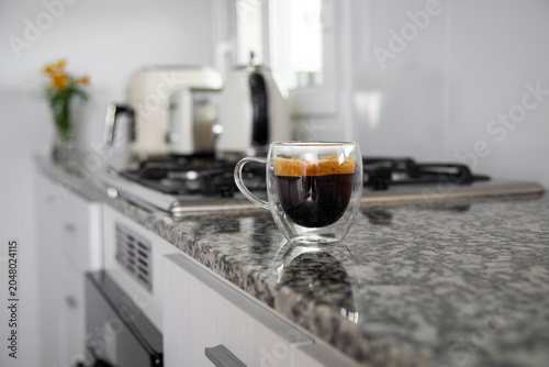 Espresso coffee in double walled glass cup on kitchen counter