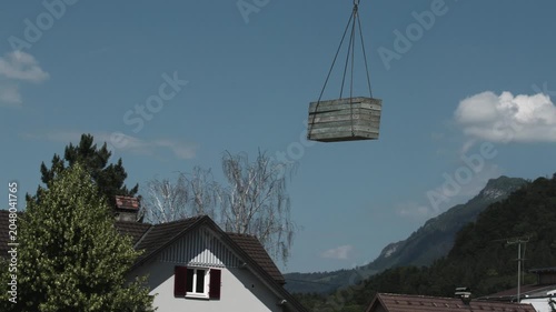 Crane Transporting Metal Formwork Panel Above Residential Area