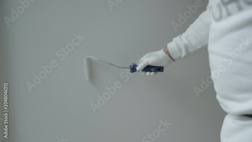 Close-Up of Professional Painter Applying White Paint with Roller on Interior Wall