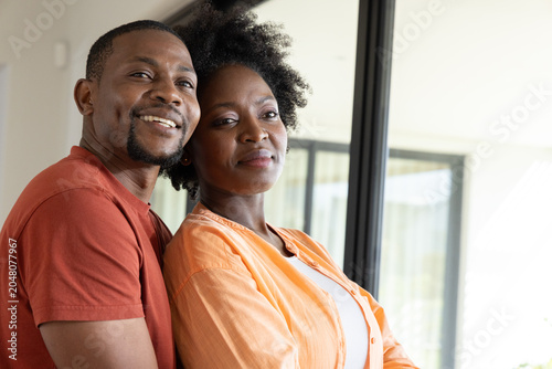 Canvastavla African American couple standing inside modern home near sliding glass door, wea