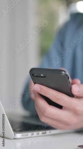 Close Up of Male Hand with Laptop using Smartphone, Vertical Video
