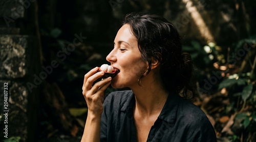 Woman enjoying a ripe mangosteen fruit in a tropical setting