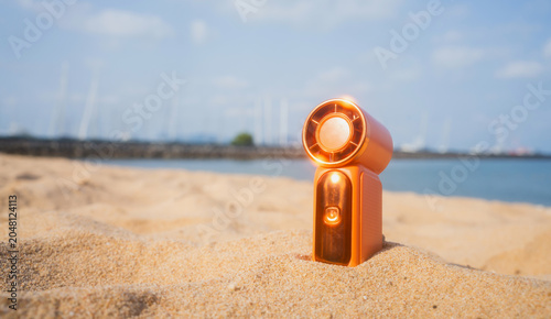 Photos Portable handy fan on the beach and the background is the sea and the sky in summer