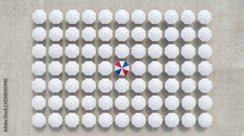 Patriotic umbrella standing out among white umbrellas representing freedom, individuality, national pride, and American Independence Day.
