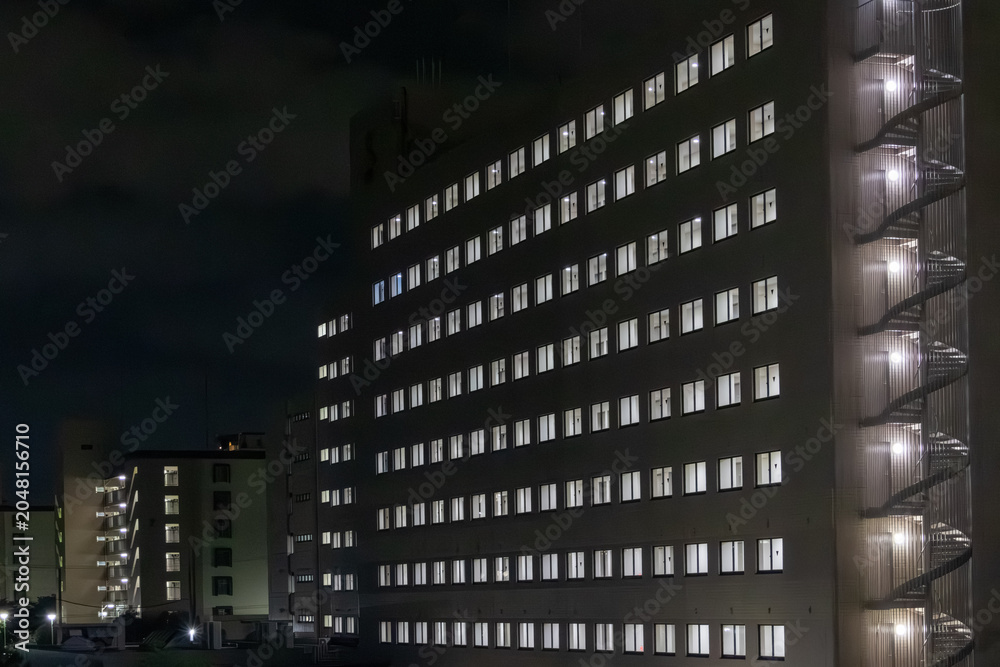 Fototapeta premium Residential building with illuminated windows at night
