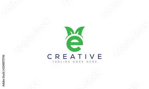 Letter e logo design with green leaves symbol