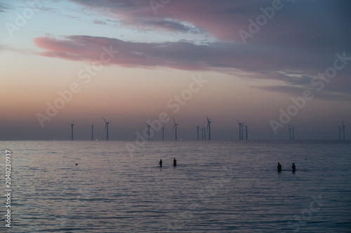 Offshore Wind Turbines on Ocean Horizon at Dawn from Geumneung Beach Jeju Island, South Korea