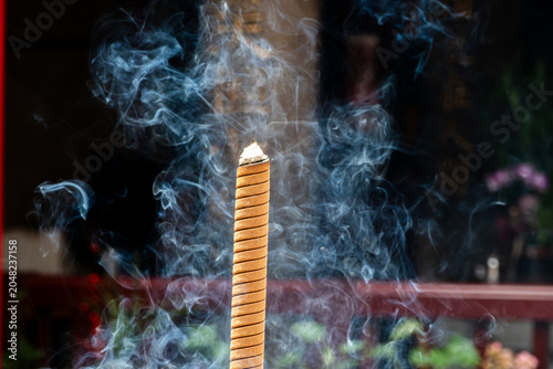 Photos Beautiful swirling smoke from a burning joss stick, conceptual image for Zen, meditation, mindfulness, spiritual cleansing, and aroma relaxation