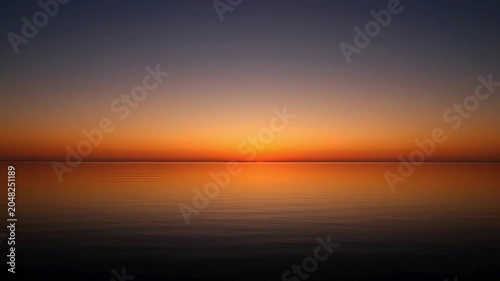Sunset over calm sea water.