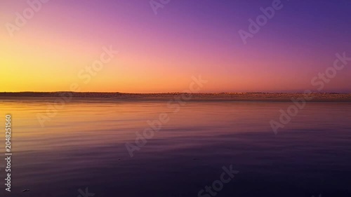 Sunset over calm sea water.