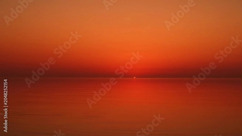 Sunset over calm sea water.