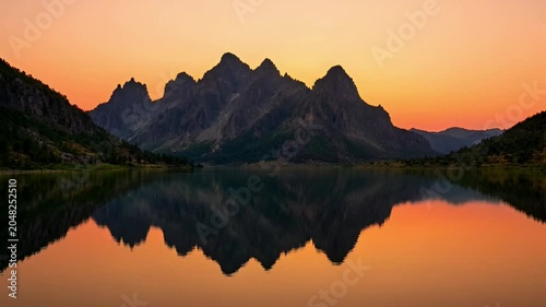 Sunset over mountain lake reflection.