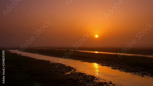 Sunset over serene water landscape.