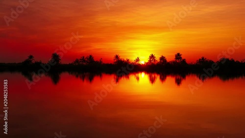 Sunset over water with trees.