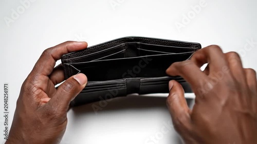 Black man hands holding an open empty leather wallet over a white background