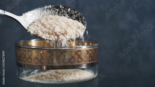 Pouring psyllium husk into a glass for cooking at home