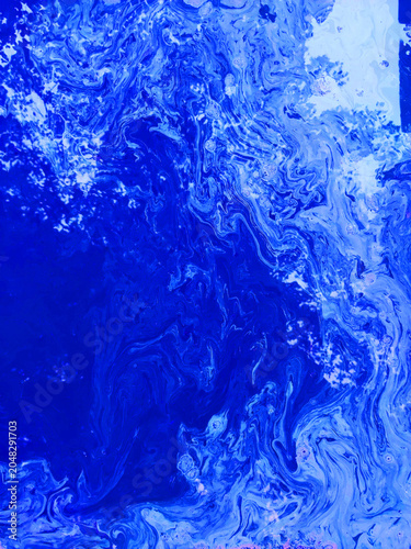 Saturated luminous blue liquid marble texture with dynamic acrylic paint swirls and white details