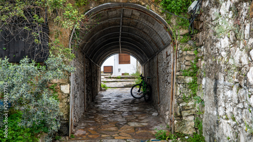A stone archway tunnel in Marmaris old town alleyway with a bicycle parked inside. Historical Turkish urban exploration scene
