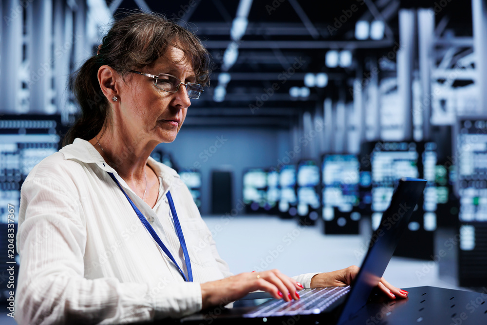 Fototapeta premium Elderly adept technician inside high tech facility providing computing resources needed for AI to process extensive datasets for training. Server hub storing data used for machine learning