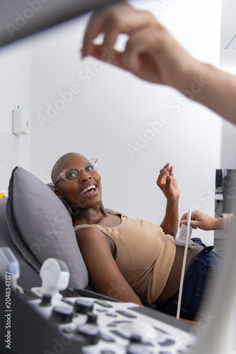 African American patient reclining on exam chair while clinician using ultrasound probe at clinic