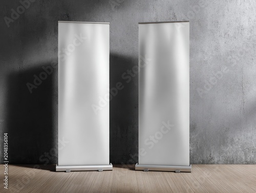Two vertical, blank display stands on a wooden floor in front of a textured, grey wall, lit by soft light