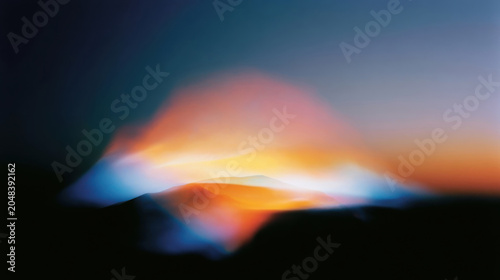 Abstract blurred mountain landscape at sunset with warm orange and cool blue light rays creating ethereal atmospheric glow