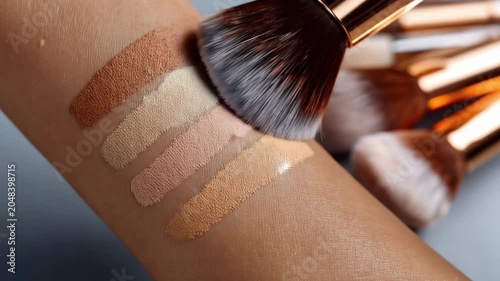 Makeup swatches on skin with brushes showing different shades and colors at a cosmetic display