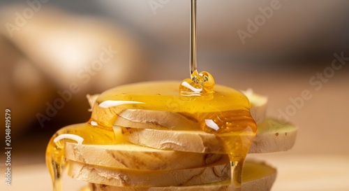 Golden Honey Drizzling Onto Stacked Slices of Bread.