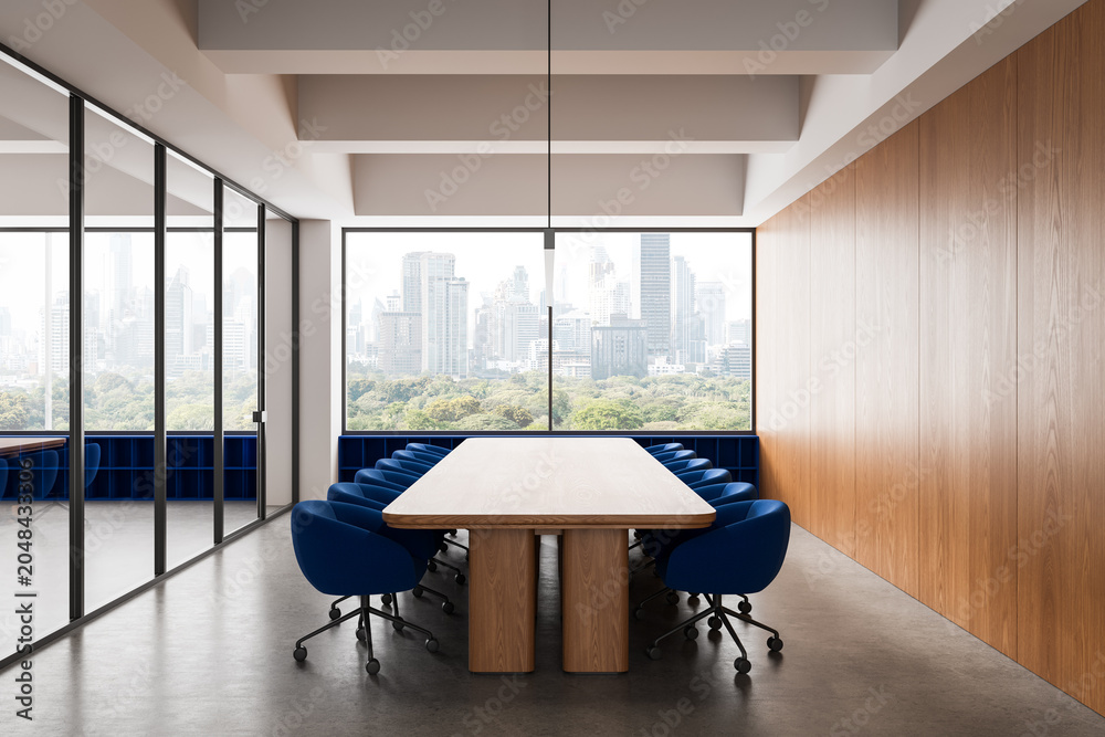 Fototapeta premium Modern conference room with long wooden table, blue chairs, glass walls and skyline view in bright office interior setting. 3D Rendering
