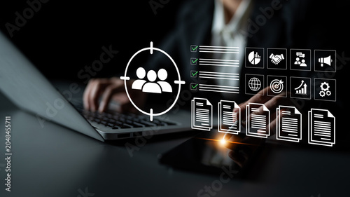 Fotografía A business professional engages with a laptop in a dimly lit environment, featuring a target icon and visual data representations, symbolizing digital analysis and strategic planning