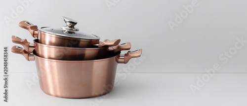 Foto Golden cooking pots on light background