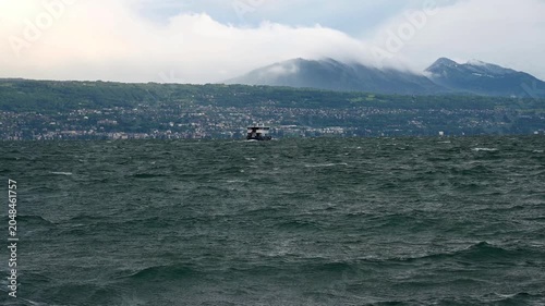 Real Time of Boat on Lake Geneva with Dramatic Waves and Swiss Shoreline in Switzerland.