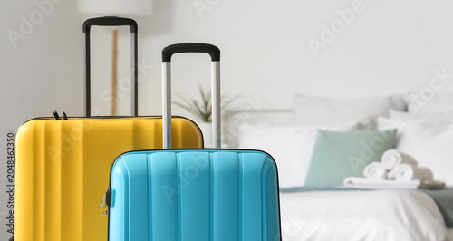 Suitcases near bed in light...