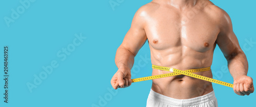 Male bodybuilder measuring ...