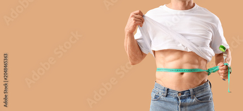 Male bodybuilder measuring ...