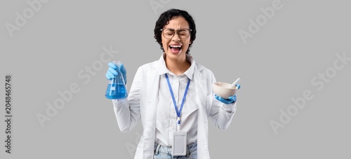Screaming African-American female scientist with mortar, pestle and flask on ...