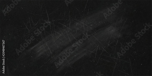 Foto A dark, textured surface, perhaps a blackboard or a scratched metal panel, presents a gritty and industrial aesthetic