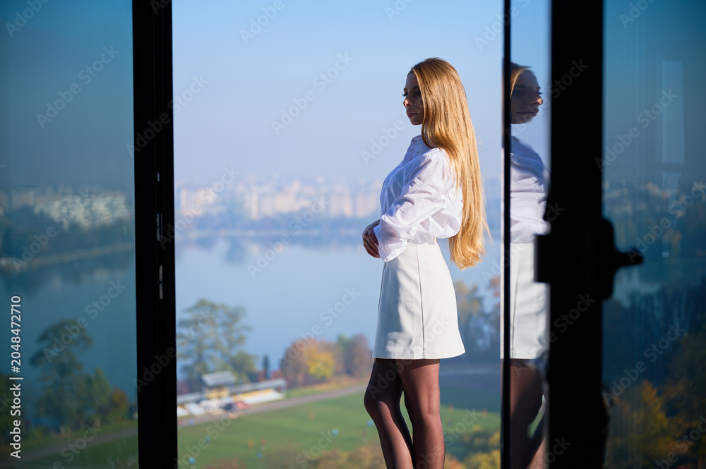 Naklejka premium Woman as real estate manager showcasing future living space and balcony outlook in unfinished flat. Concept of property presentation, residential sales, branding and commercial use