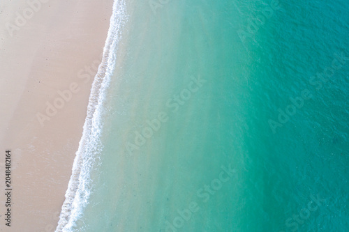 Bild auf Leinwand Aerial view of ocean waves meeting the sandy beach The Concept of summer vacatio