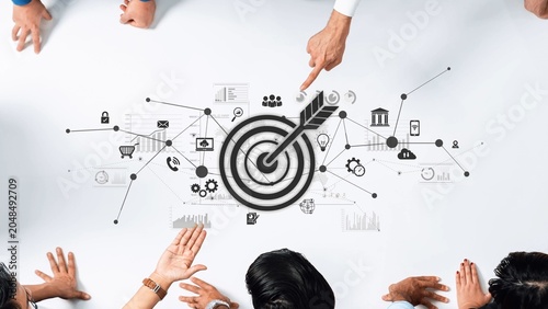 Tableau sur toile This image showcases a collaborative business strategy concept featuring diverse hands pointing at a central target illustration with various data icons, symbolizing success