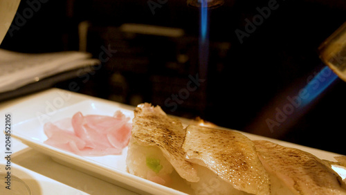 Fotografie Chef Searing Nigiri Sushi with Blue Blowtorch Flame in Kanazawa