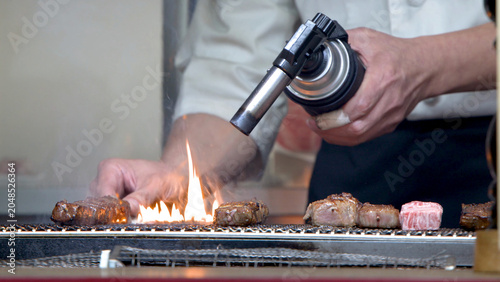 Bild auf Leinwand Chef Searing Wagyu Beef with a Gas Blowtorch on a Grill