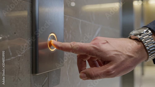 Close up of metallic elevator call button in marble lobby