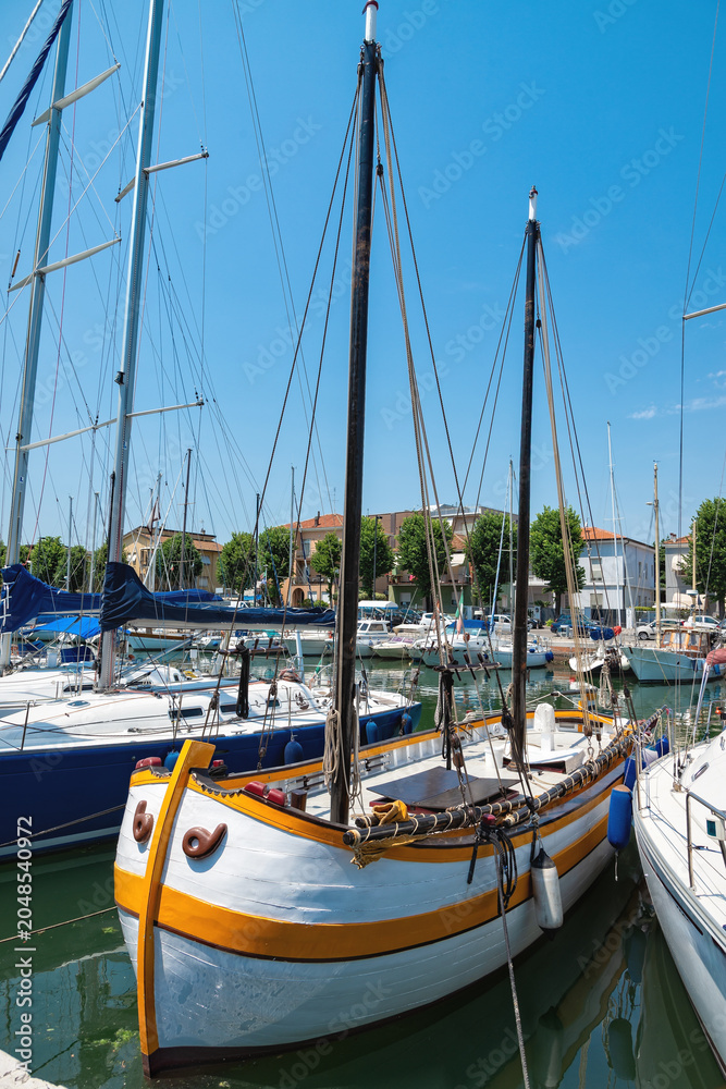 Obraz premium Sailboats docked at a marina under clear blue skies on a sunny day