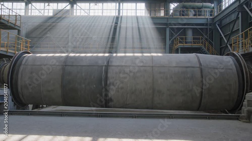 Industrial factory interior with large pipe and sunbeams