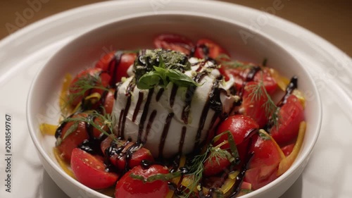 Appetizing Italian burrata cheese salad with cherry tomatoes, pesto, and balsamic vinegar, fa01
