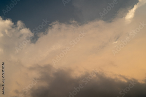 Dramatic sky with soft clouds transitioning from dark to light hues at sunset.