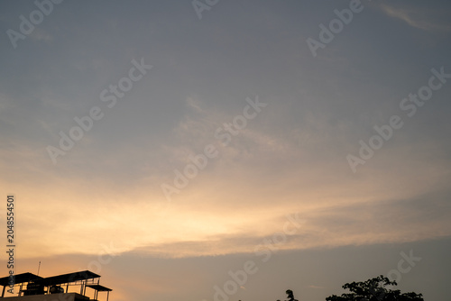 Dusk sky with soft hues and silhouetted rooftops.