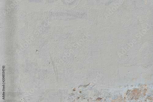 Textured gray wall with subtle peeling and stains.